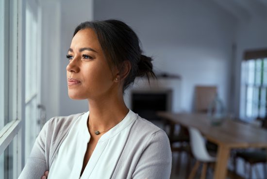 Mature,African,Woman,Looking,Outside,Window,With,Uncertainty.,Thoughtful,Mid